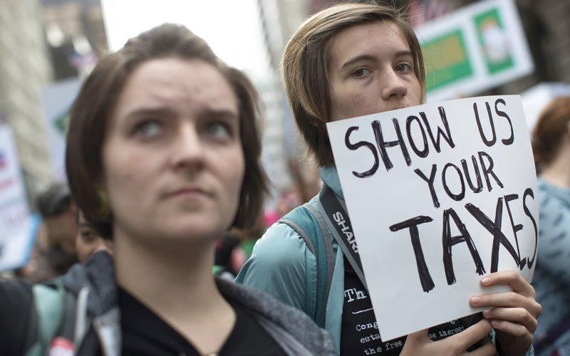 لافتة كتب عليها «اظهر سجلك الضريبي» اثناء المظاهرة. «ا.ب»