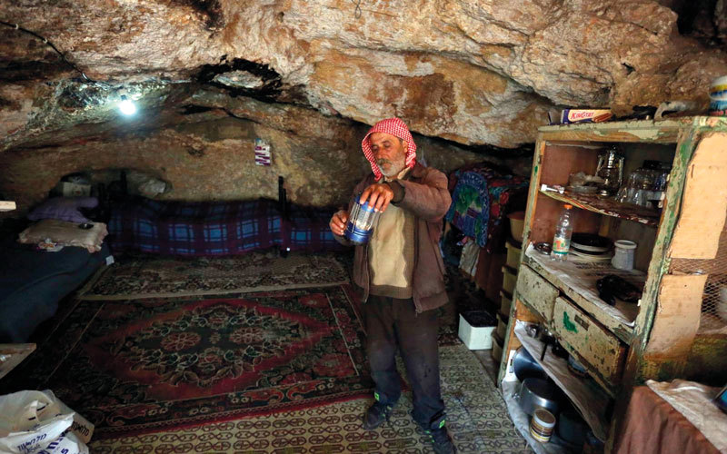 ماجد حنني يعيش هو وأسرته المكوّنة من 12 فرداً داخل كهف متهالك. الإمارات اليوم