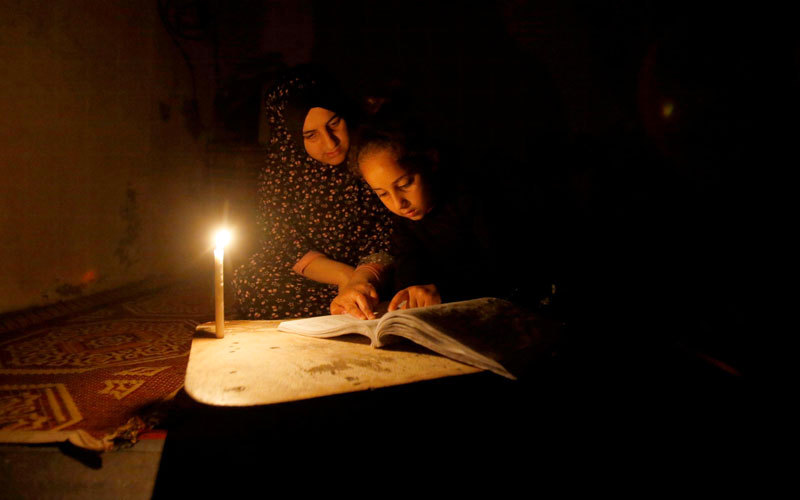 طفلة تدرس على ضوء الشموع في غزة. رويترز