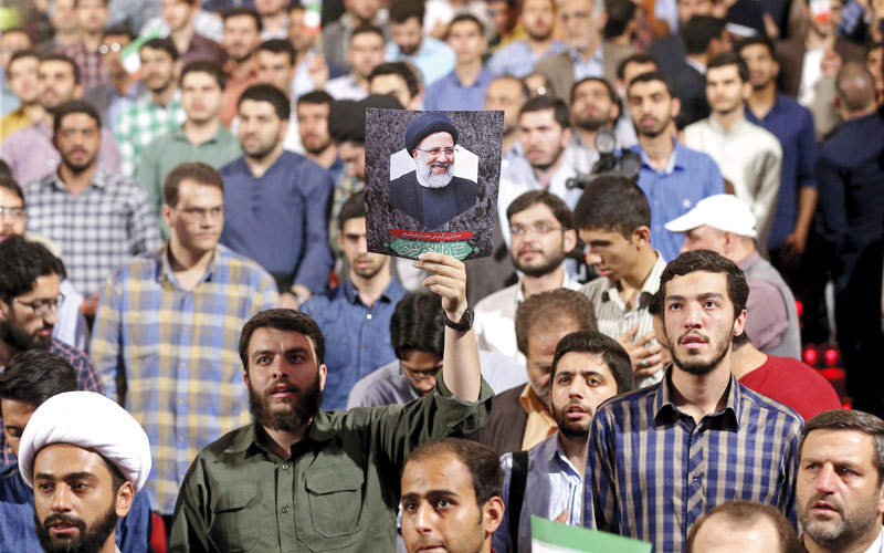 أنصار رئيسي يرفعون صورته خلال حملة انتخابية في العاصمة طهران. أ.ب