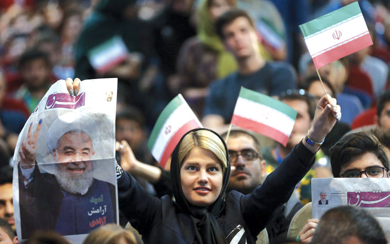 إيرانية مؤيدة للإصلاح ترفع صورة روحاني خلال مظاهرة تأييد للرئيس الإيراني. أ.ب