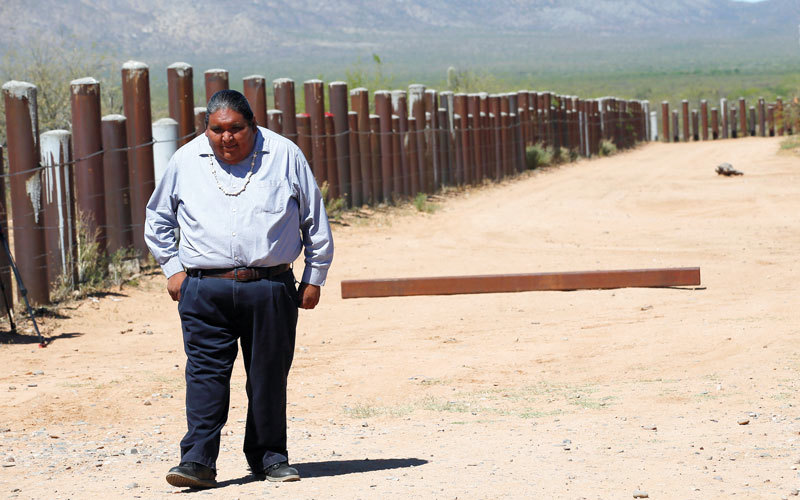 فيرلون خوسيه يمشي بجانب سياج حدودي جنوب أريزونا.  رويترز