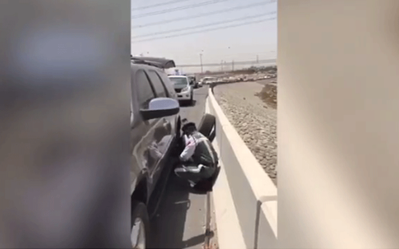 شاهد.. أحد أفراد شرطة دبي يساعد رجلاً في تبديل إطار مركبته المتعطلة