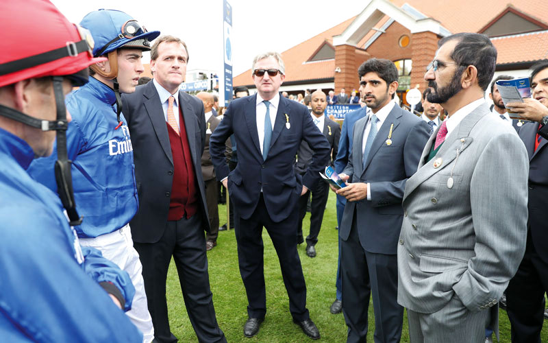 محمد بن راشد خلال متابعته سباق 2000 غينيس الإنجليزي الكلاسيكي بحضور حمدان بن محمد. وام