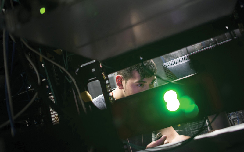 فني كمبيوتر يحاول إصلاح الضرر الذي أصاب الخادم في الشركة التي يعمل بها.  أ.ف.ب