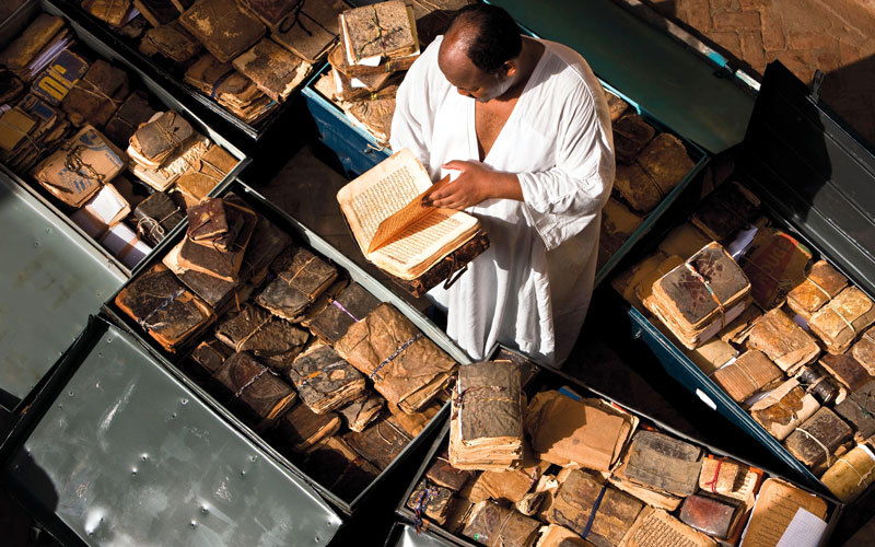 حيدرا يقرأ إحدى المخطوطات بعد جمعها في صناديق لإخراجها من تمبكتو. غيتي
