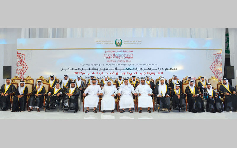 سيف بن زايد في لقطة تذكارية مع العرسان بحفلهم الجماعي. وام