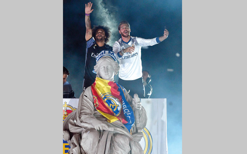 قائد ريال مدريد سيرجيو راموس ومارسيلو يلتقطان «سيلفي» أمام تمثال ساحة سيبليس. رويترز